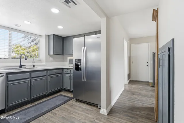 a kitchen with stainless steel appliances granite countertop a refrigerator and a sink