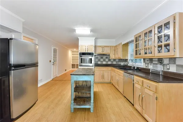 a large kitchen with stainless steel appliances granite countertop a refrigerator and a sink
