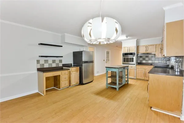 a large kitchen with stainless steel appliances kitchen island granite countertop a stove top oven a sink a dining table and chairs