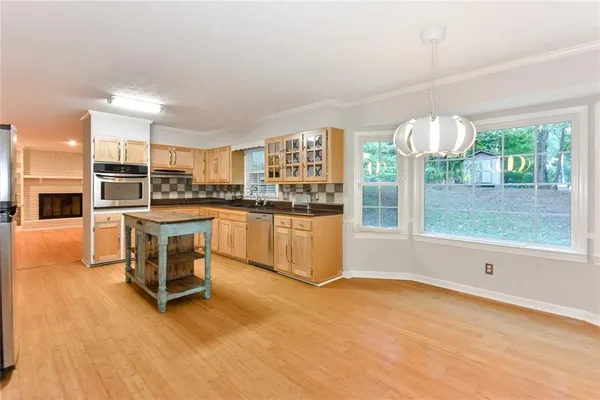 a kitchen with granite countertop a stove a sink and a refrigerator