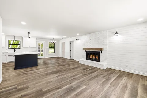 a large white kitchen with a sink and a fireplace