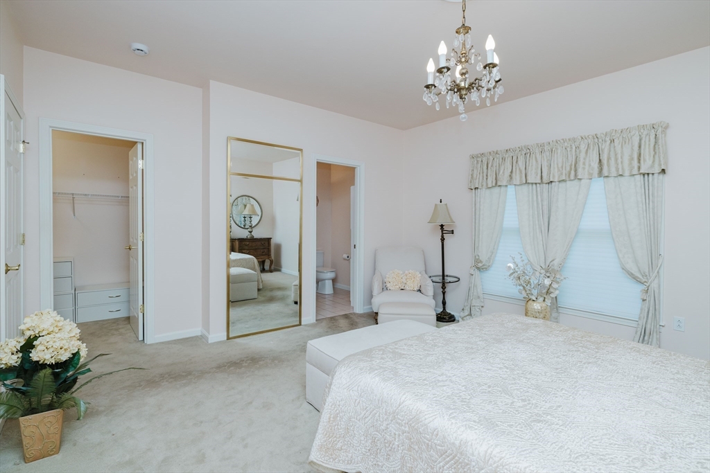32 Village Way, Unit 32 Westport, MA 02790 - Photo 11 of 15 a bedroom with a bed and a chandelier