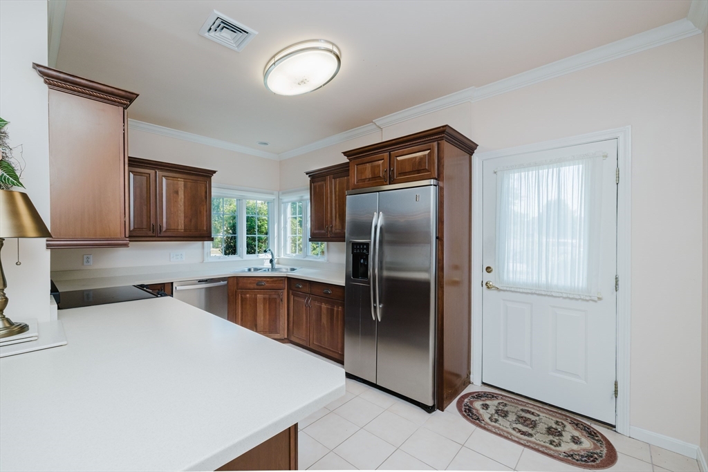 32 Village Way, Unit 32 Westport, MA 02790 - Photo 3 of 15 a kitchen with stainless steel appliances granite countertop a refrigerator a sink and a stove
