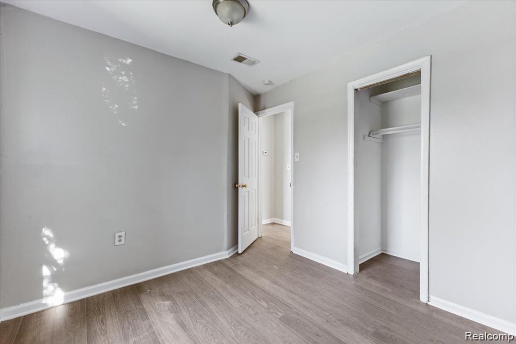 26076 Colgate Street Inkster, MI 48141 - Photo 10 of 24 Room featuring wood-finish flooring, light gray wall paint, and white trim