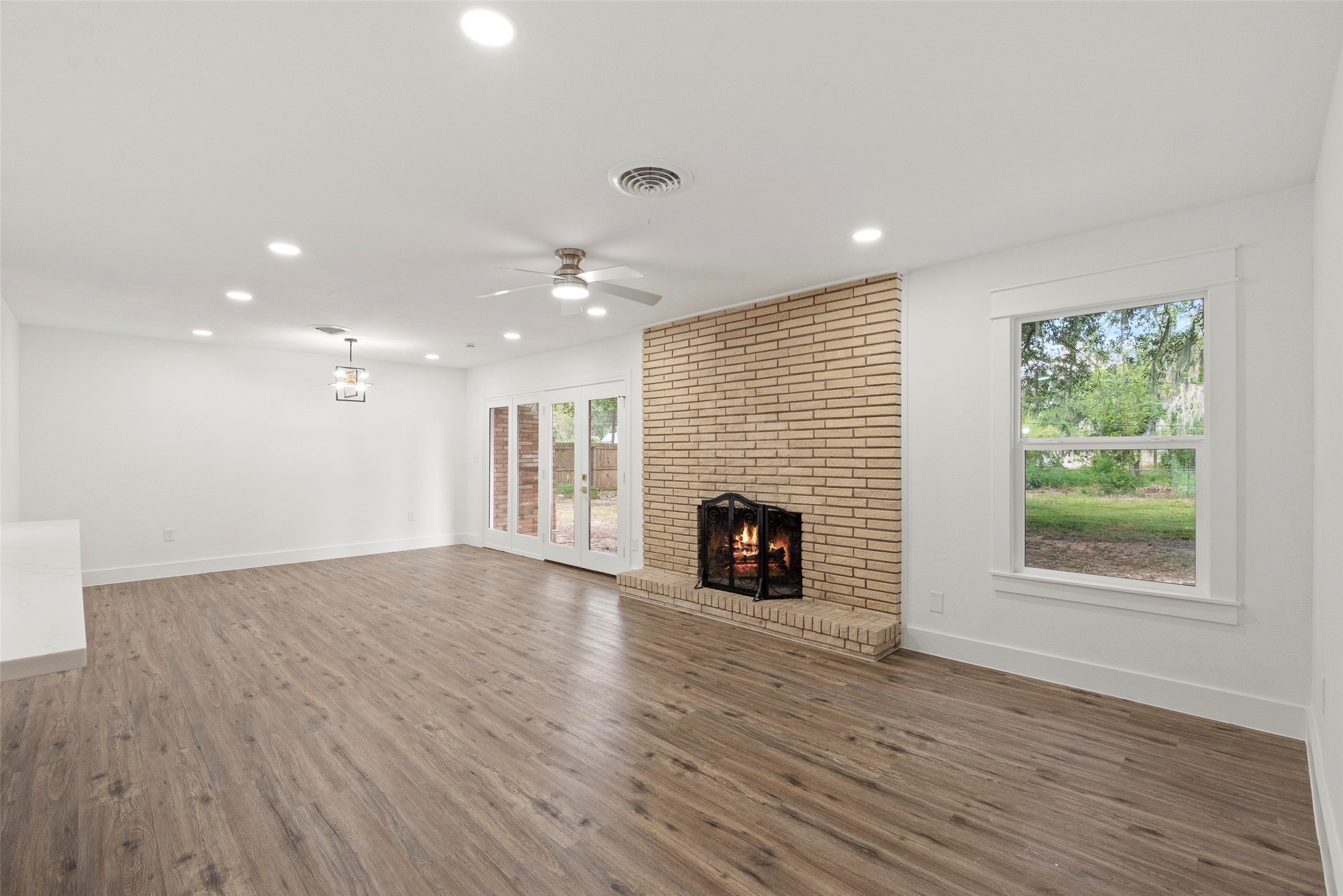 126 Daisy Street Lake Jackson, TX 77566 - Photo 16 of 36 an empty room with wooden floor fireplace and windows
