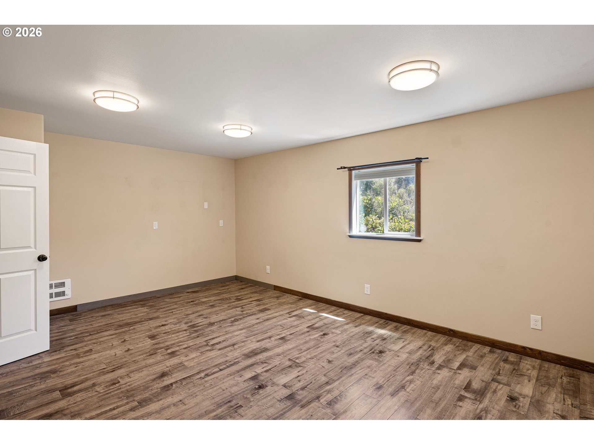 88481 1st Avenue Florence, OR 97439 - Photo 17 of 43 an empty room with wooden floor and windows