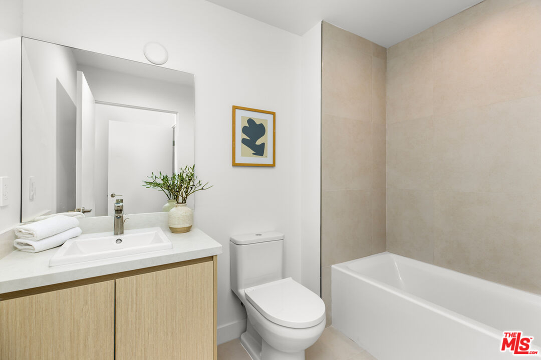 3808 College Avenue, Unit 2 Culver City, CA 90232 - Photo 12 of 15 a bathroom with a granite countertop sink a toilet and shower