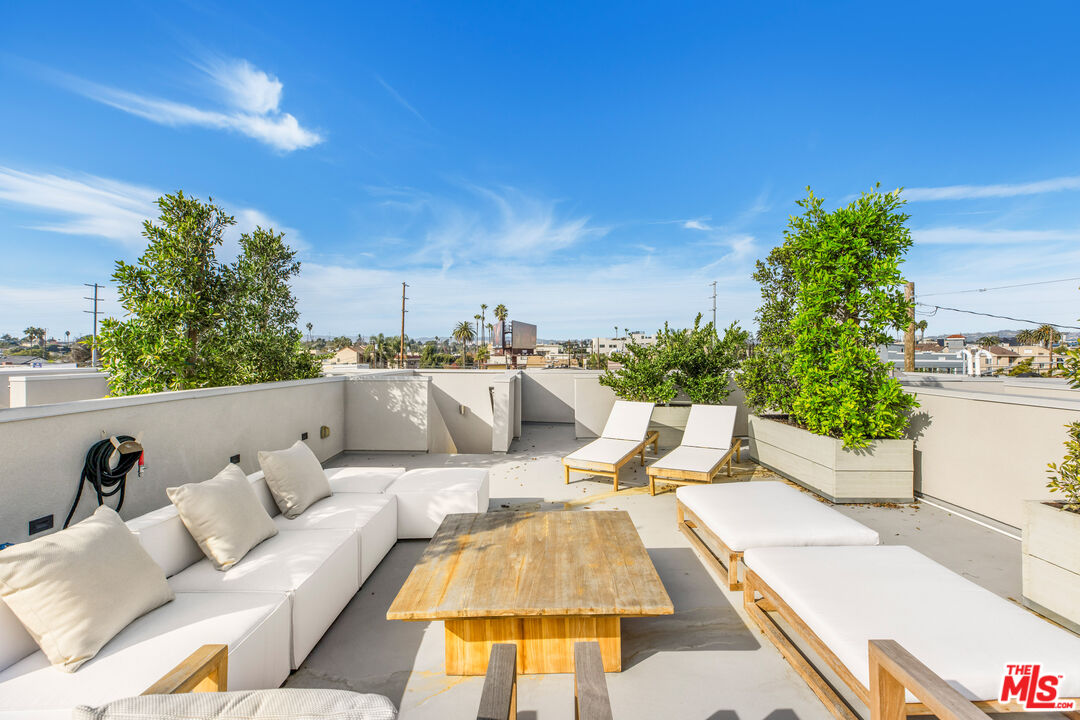 3808 College Avenue, Unit 2 Culver City, CA 90232 - Photo 14 of 15 a view of a patio with couches and a table and chairs with wooden floor and fence
