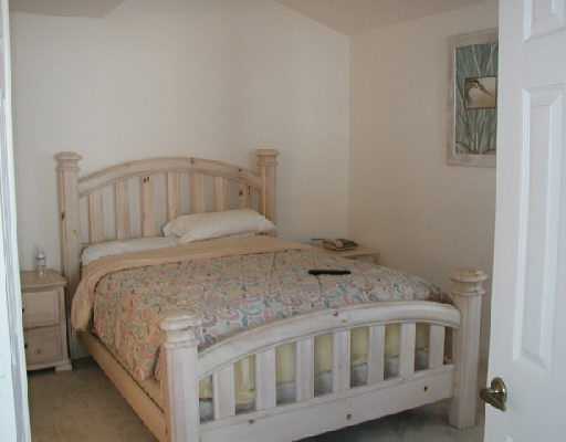 1154 Via Jardin, Unit 1154 Riviera Beach, FL 33418 - Photo 11 of 16 a bedroom with a bed and a table