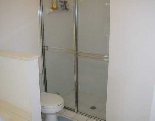 1154 Via Jardin, Unit 1154 Riviera Beach, FL 33418 - Photo 13 of 16 a bathroom with a granite countertop toilet and a shower