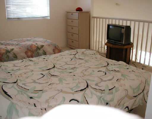 1154 Via Jardin, Unit 1154 Riviera Beach, FL 33418 - Photo 14 of 16 a bedroom with a bed and a flat screen tv