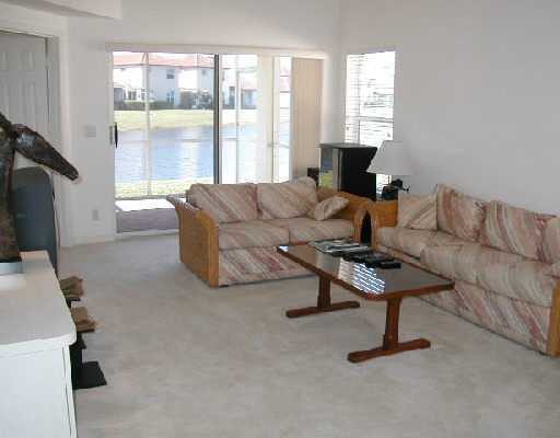 1154 Via Jardin, Unit 1154 Riviera Beach, FL 33418 - Photo 9 of 16 a living room with furniture a large window and a flat screen tv