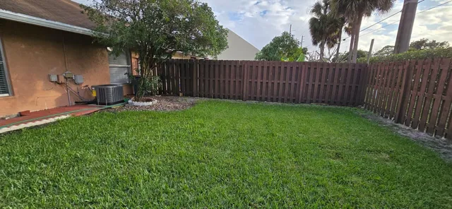 a view of a backyard with table and chairs and wooden fence