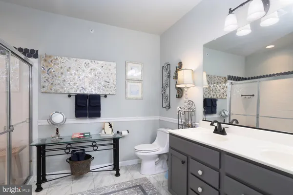 a bathroom with a double vanity sink toilet and mirror