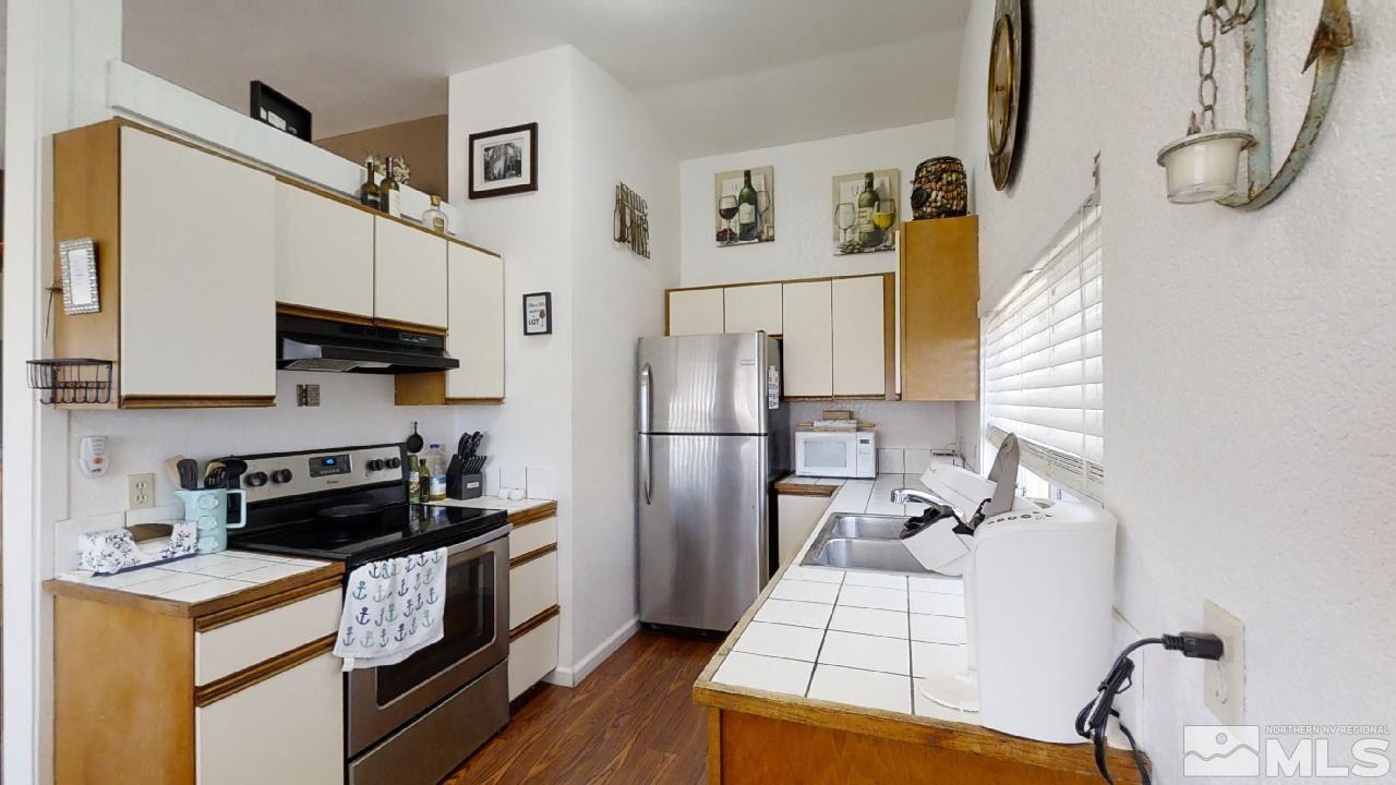 7015 Indigo Circle Reno, NV 89506 - Photo 6 of 12 a kitchen with a refrigerator and a stove top oven
