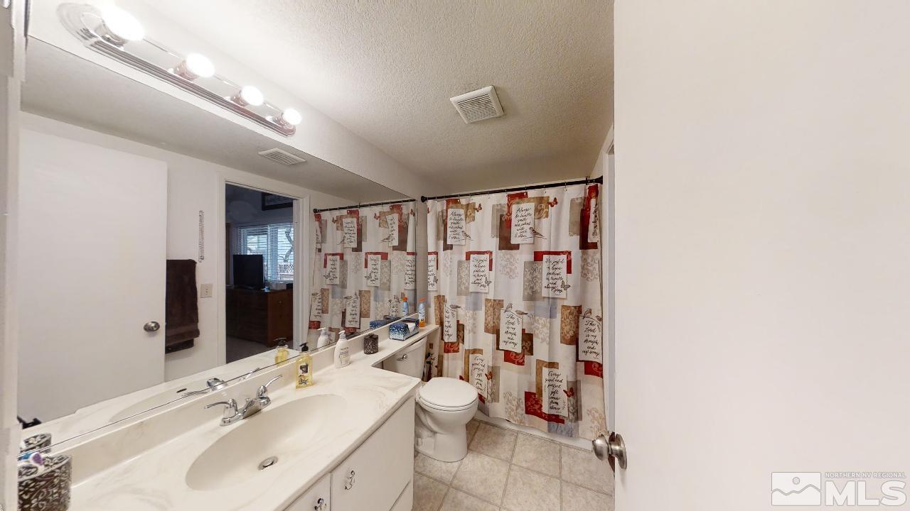 7015 Indigo Circle Reno, NV 89506 - Photo 8 of 12 a bathroom with a double vanity sink toilet and shower