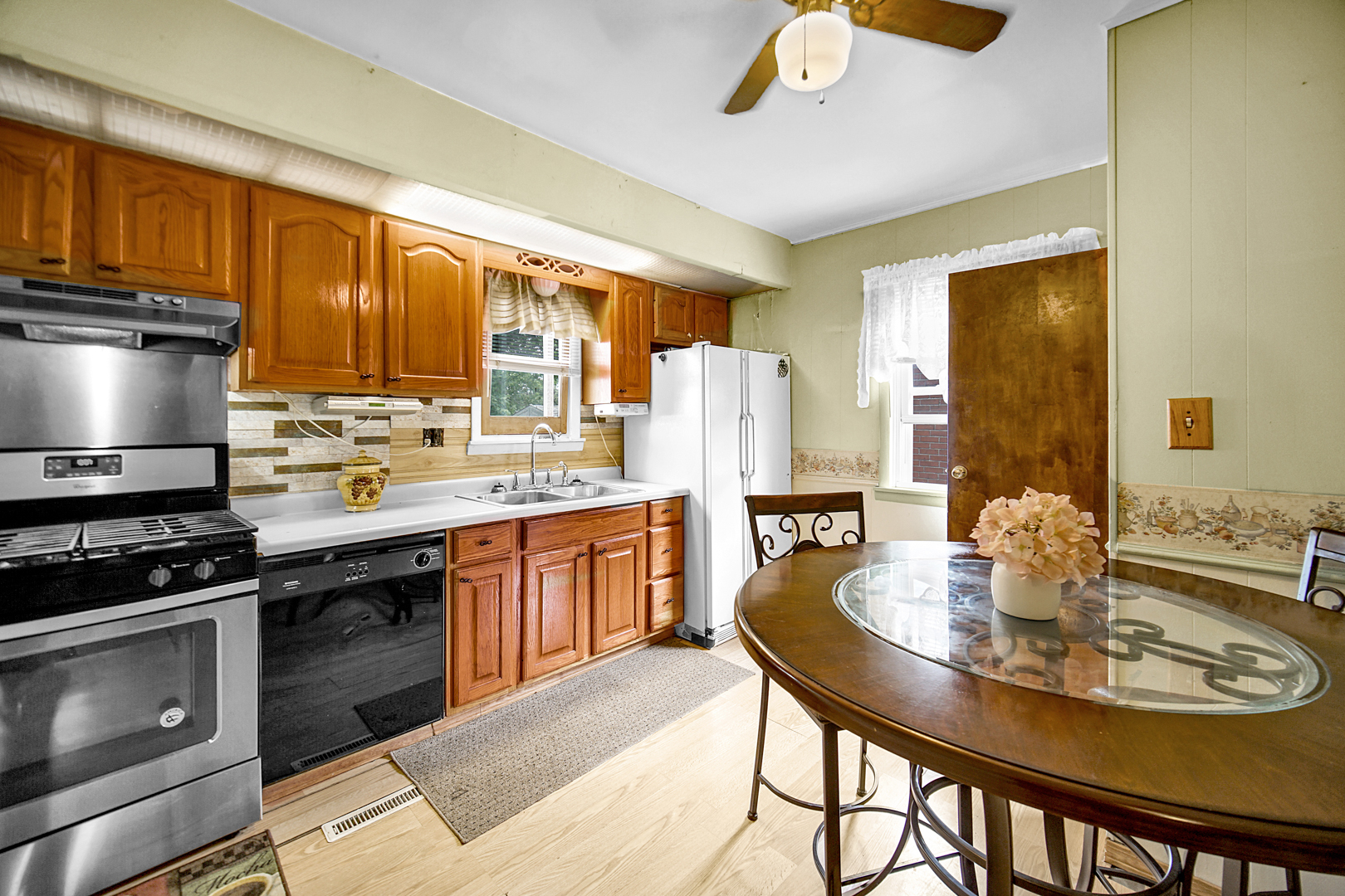 1453 Shell Street Hammond, IN 46320 - Photo 8 of 23 a kitchen with a stove a sink a dining table and chairs