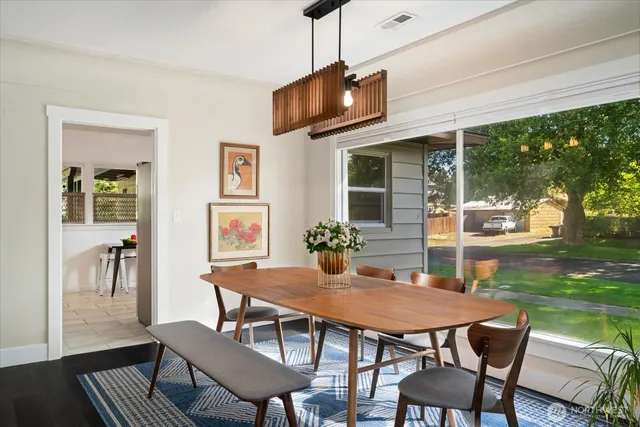a dining room with wooden floor a chandelier a wooden table and chairs