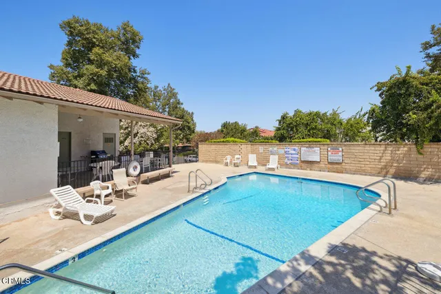 a view of a backyard with a patio and swimming pool