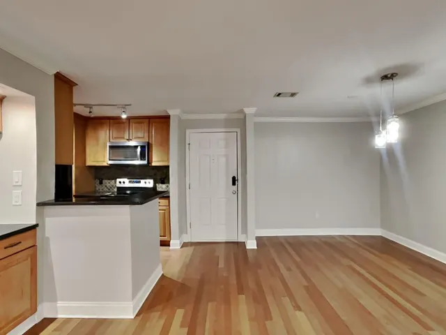 a kitchen with granite countertop a refrigerator and a stove top oven