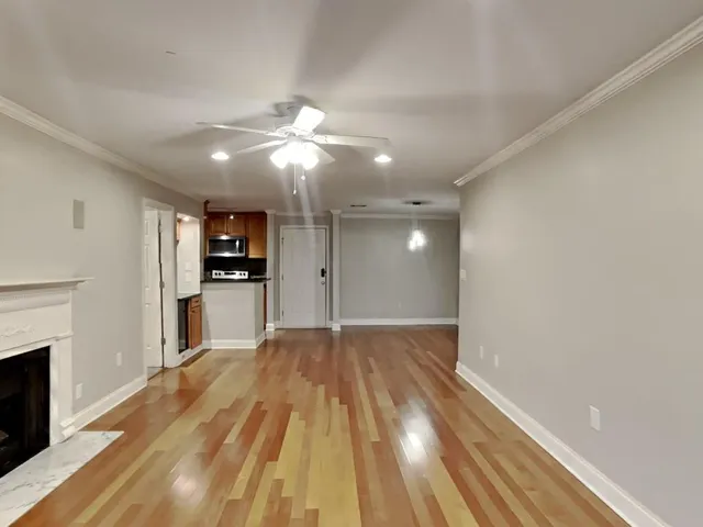 a view of empty room with kitchen and fireplace