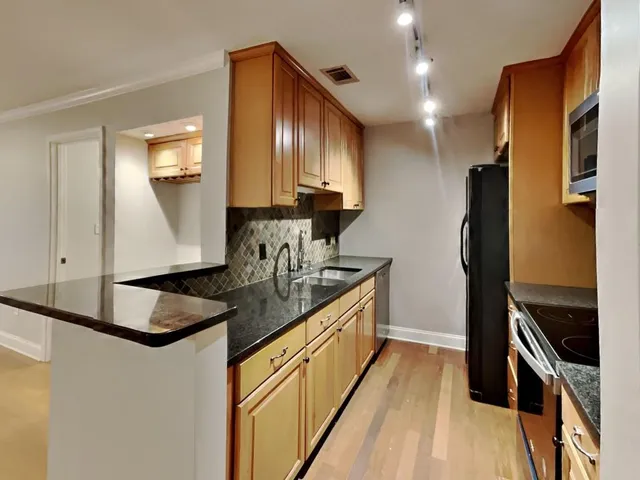 a kitchen with stainless steel appliances granite countertop a sink stove and refrigerator