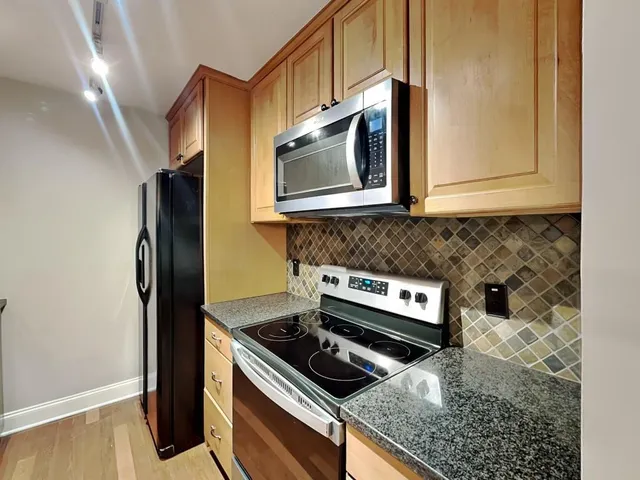 a kitchen with stainless steel appliances granite countertop a stove and a microwave