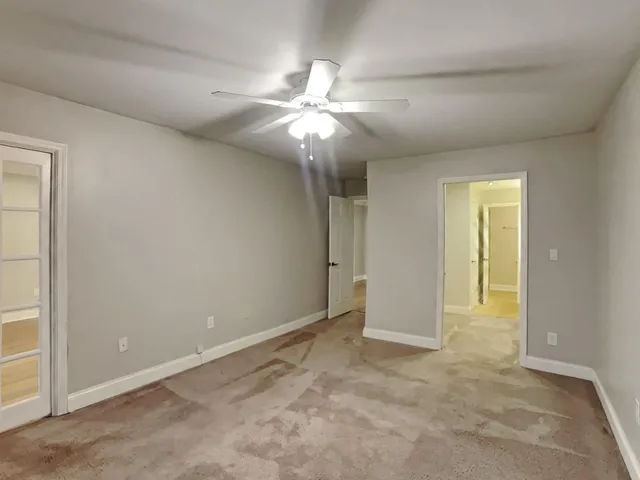 an empty room with closet and a chandelier fan