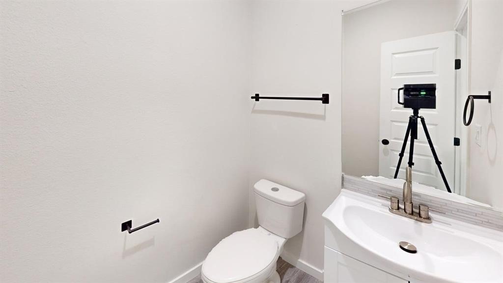 6702 South Lancaster Road Dallas, TX 75241 - Photo 18 of 20 White vanity with an integrated sink, brushed nickel faucet, and a subway tile backsplash