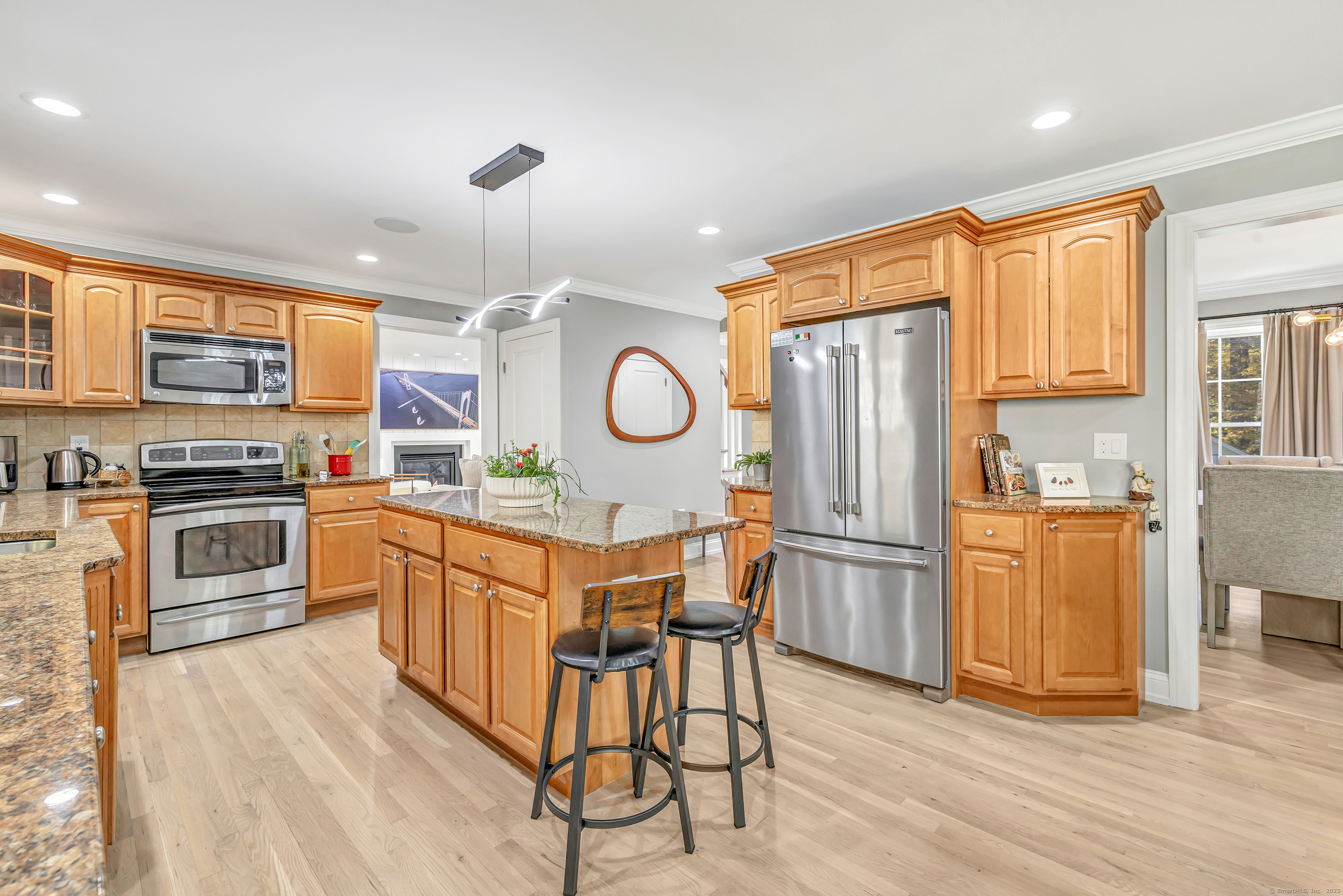 6680 Main Street Trumbull, CT 06611 - Photo 13 of 40 a kitchen with stainless steel appliances granite countertop a refrigerator a stove top oven a sink dishwasher and white cabinets with wooden floor