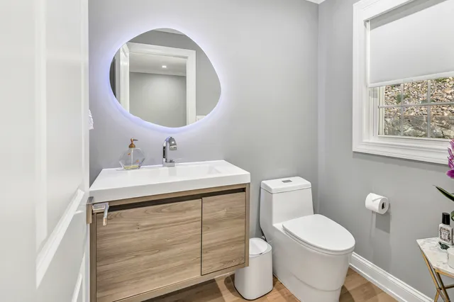 a bathroom with a toilet sink and mirror