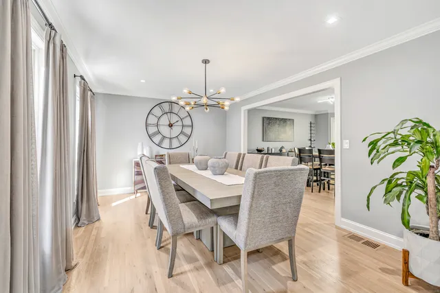 a view of a dining room with furniture a chandelier and wooden floor