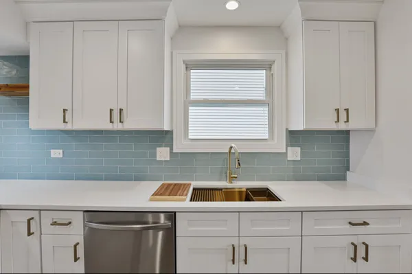 a kitchen with a sink cabinets and white countertops