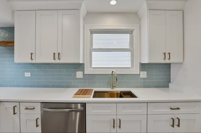a kitchen with a sink cabinets and white countertops