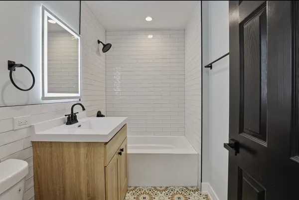 a bathroom with a sink a toilet and shower