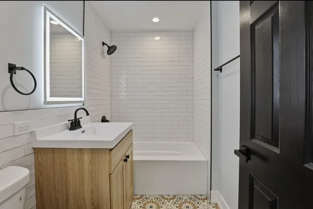 a bathroom with a sink a toilet and shower