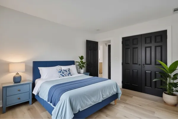 a bedroom with a bed and a potted plant