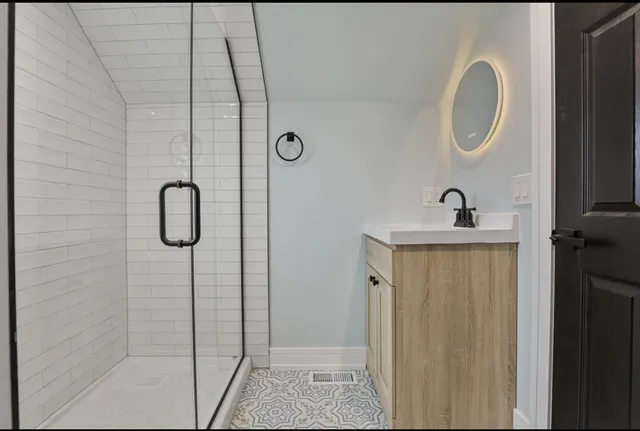 a bathroom with a sink a mirror and shower