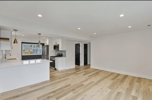 a large kitchen with stainless steel appliances kitchen island a large counter top and a stove top oven