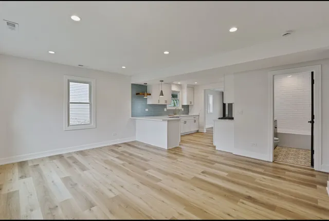 a view of kitchen with white cabinets and wooden floor