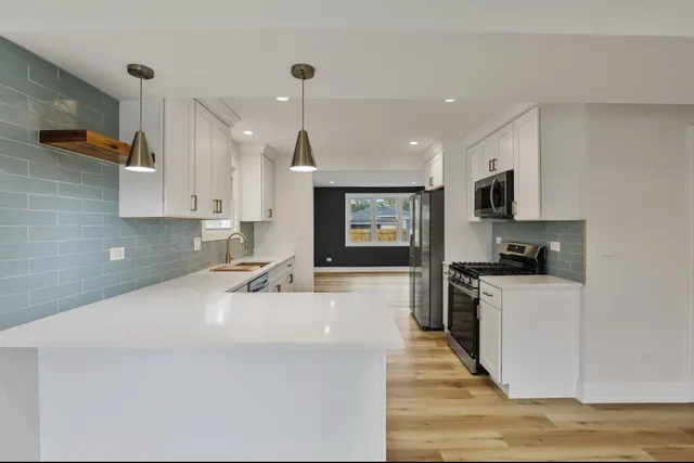 a kitchen with a sink a stove and a refrigerator