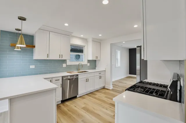 a large kitchen with white cabinets and a stove