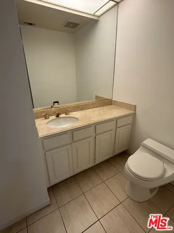 a spacious bathroom with a granite countertop toilet and a sink