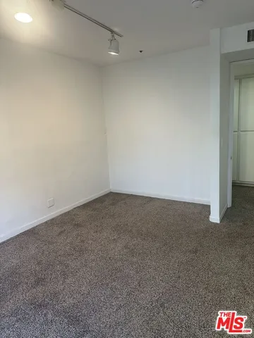 a view of an empty room with a floor to ceiling window and a ceiling fan