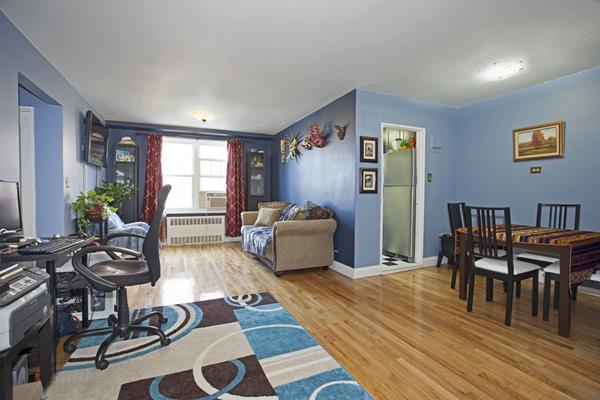 140-21 Burden Crescent, Unit 306 Queens, NY 11435 - Photo 2 of 5 a bedroom with furniture and a wooden floor