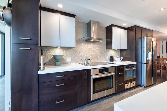 a kitchen with stainless steel appliances granite countertop a stove a sink and a refrigerator