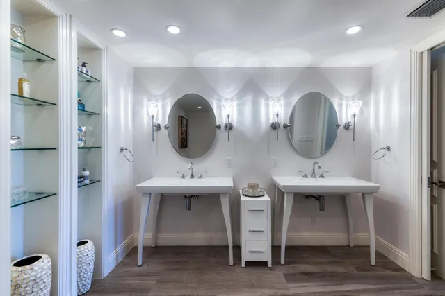 a bathroom with double vanity sinks and a mirror