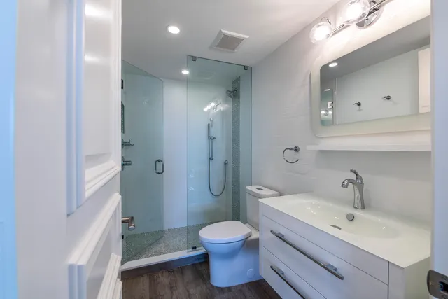 a bathroom with a toilet sink a mirror and shower