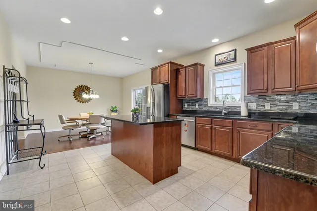 a kitchen with stainless steel appliances granite countertop a stove refrigerator and cabinets