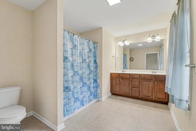 a spacious bathroom with a granite countertop sink toilet and shower